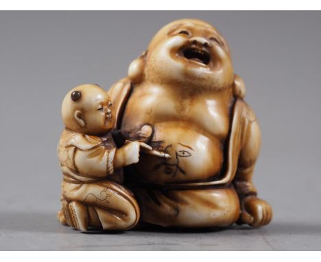 A Japanese carved ivory netsuke Hotei with acolyte painting on his stomach, signed, 1 1/4" highCondition:No apparent conditio