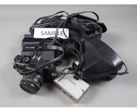 An Olympus OM10 camera, in case, a Petri GX-1 camera, a Canon 514XL camera, and other cameras and equipment 