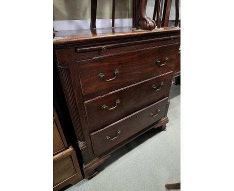 A bachelor's Georgian mahogany chest with fluted columns, fitted slide over three long graduated drawers with brass bail hand