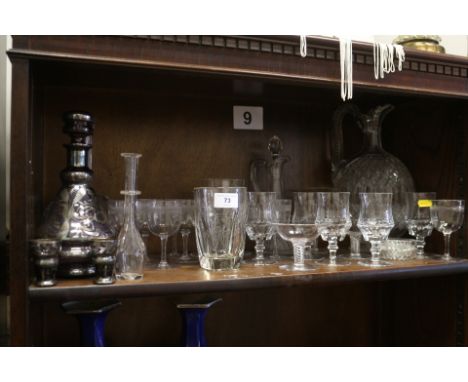 A clear glass toddy ladle, two decanters, pedestal glasses and other glassware