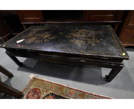 A Chinese black and gold lacquered low occasional table, on scroll end supports, 49" wide x 24" deep x 14" high 