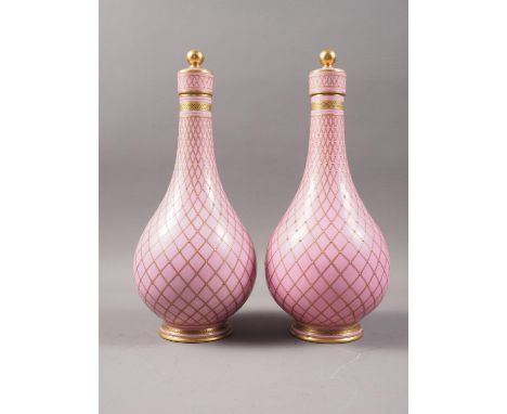 A pair of Sevres style porcelain bottle vases and covers with all-over lattice decoration on a pink ground, 10 1/2" high Cond
