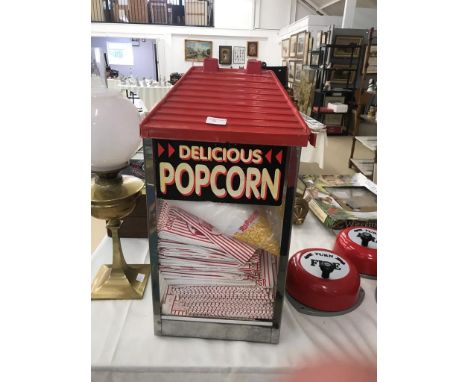 A vintage popcorn machine with cups, bags etc