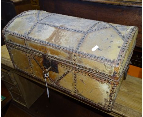 An early 19th century skin covered and studded upholstered dome top trunk with steel carrying handles and  lock, width 1'10",