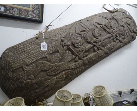 A carved wood tribal panel, possibly South American.