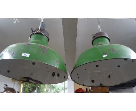A pair of green and white enamel industrial ceiling light shades.