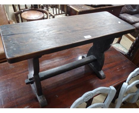 A rustic oak bench/stool of small size, width 2'6", height 1'5".