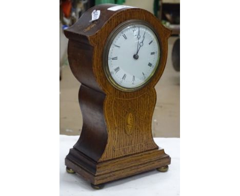 An Edwardian oak cased mantel clock with shell motif.