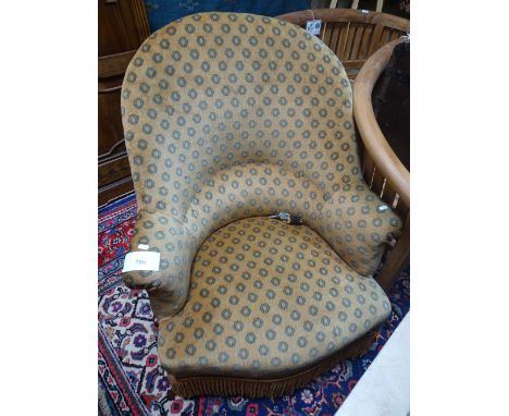 An Edwardian upholstered bow armchair.