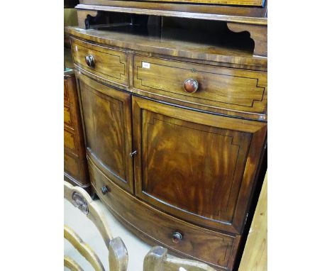 A 19th century mahogany bow front dwarf linen press, with 2 short frieze drawers above panelled doors opening to reveal fitte