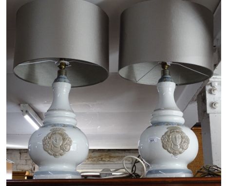 A pair of large Lladro ceramic table lamps with mask decoration and shades.