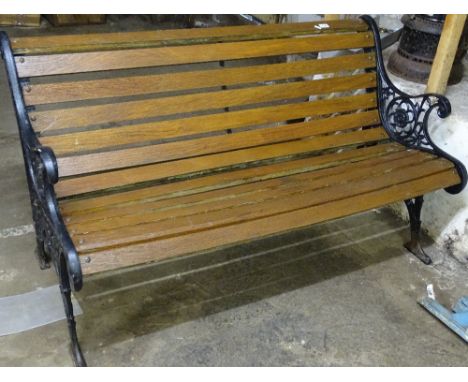 A hardwood slatted garden bench, cast-iron ends, W 136cm