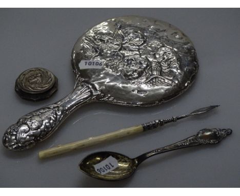 An Art Nouveau embossed silver-backed dressing table mirror, a silver and ivory handled pickle fork, a small silver pillbox e