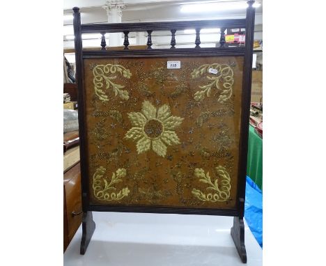 A Victorian embroidered fire screen in walnut frame