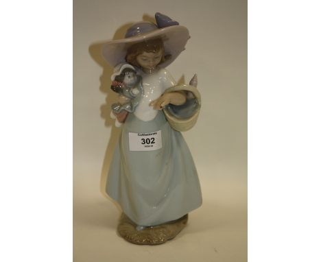 A NAO FIGURE OF A GIRLS HOLDING A DOLL AND A BASKET