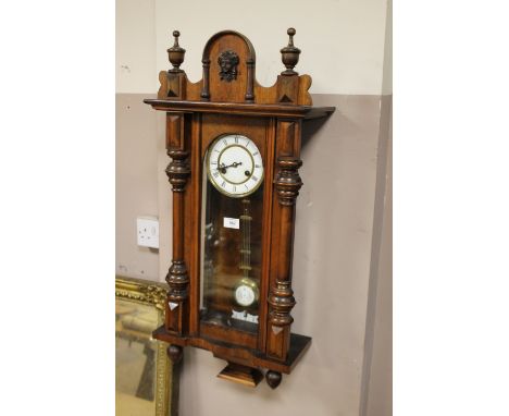 AN ANTIQUE VIENNA WALLCLOCK, the enamel dial with Roman numerals, half turned pilasters to the case, pendulum, key, H 98 cm