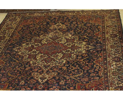 A Persian carpet, the central panel set with stylised starburst floral decorated medallion on a profusely floral decorated bl