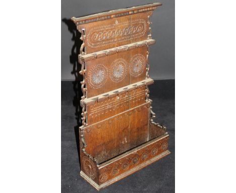 A 19th Century carved oak spoon rack in the 17th Century style, the two tier rack over a medallion carved base, 41 cm wide x 