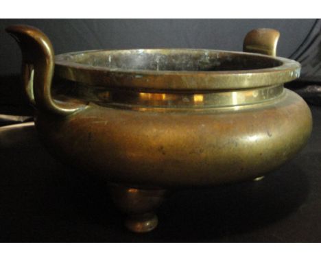 A 19th Century Chinese brass censer of squat form with two handles, raised on three legs, the base bearing six character seal