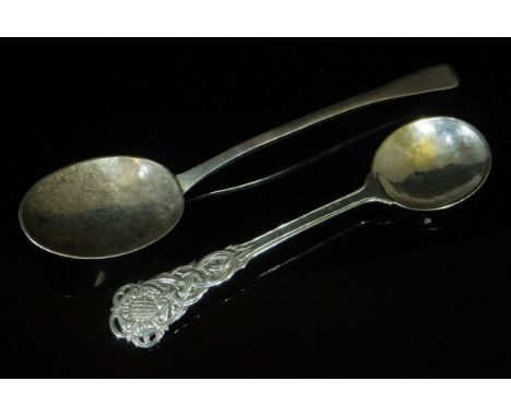 An Arts and Crafts beaten silver spoon with ornate Tudor Rose and scrollwork decorated handle (by Omar Ramsden, London, 1926)