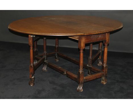 A 19th Century walnut oval gate-leg drop-leaf dining table in the circa 1700 Flemish manner, the top with moulded edge above 