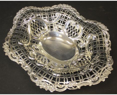 A Victorian silver pierced fruit basket with C scroll and floral and bow decoration of elongated octagonal form, raised on an