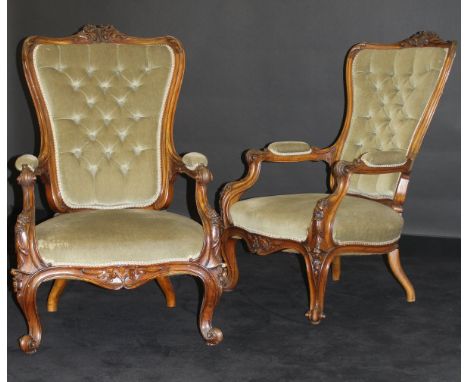 A pair of Victorian walnut framed salon chairs with carved floral show frames, button back, green velvet upholstery, raised o