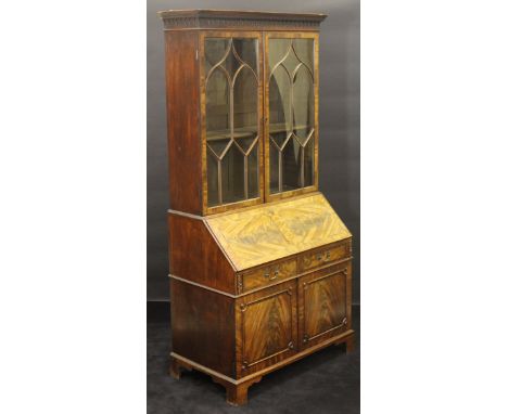 A George III mahogany bookcase cabinet, the upper section with moulded and Greek key decorated cornice, over two astragal gla