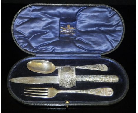 A George V cased silver Christening set comprising knife, fork, spoon and napkin ring, all with heavy floral and bird decorat