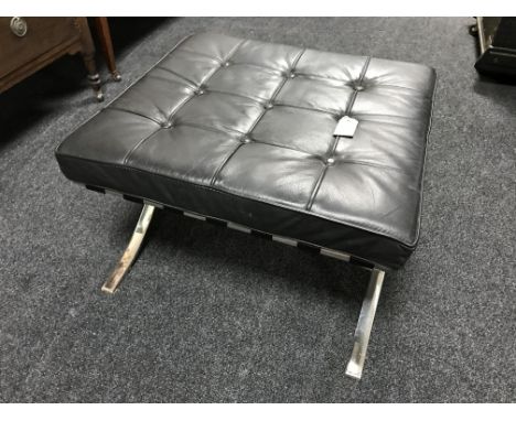 A black button leather footstool on chrome X frame support 