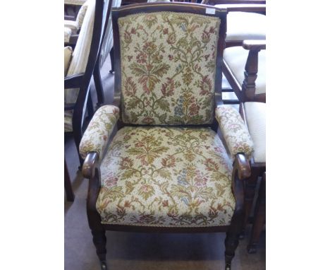 A Victorian Arm Chair, with swept back on turned legs and  brass casters, tapestry covering.
