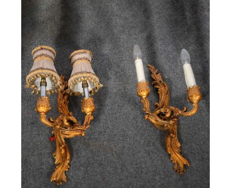 Three lacquered gilt metal two-light wall brackets, with Rococo scrolls, 44cm, wit candle-style fitments; together with a sim