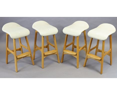 A set of four light oak bar stools each on four square legs with plain stretchers, &amp; with a padded seat. 