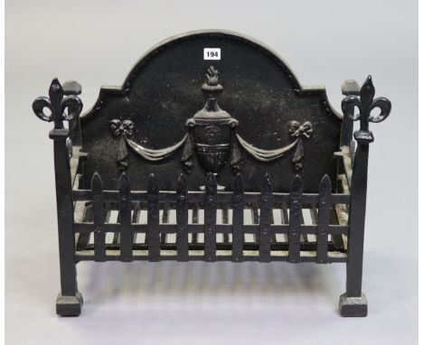 A black painted cast-iron fire-grate with raised vase design to the rounded back, 61cmn wide x 46cm high.