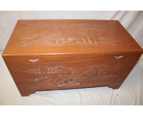 A Chinese carved camphor rectangular trunk carved with landscape scenes 40" long