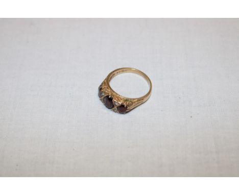 A 9ct gold dress ring with scroll mounts set garnets (3.4g)