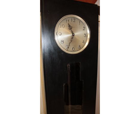 A 1930s Art Deco ebonised grandfather-style clock by Enfield with silvered circular dial and chromium plated weights with mat