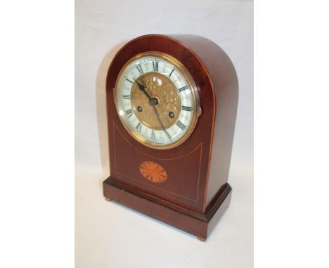 A late Victorian/Edwardian mantel clock with brass mounted decorated circular dial in inlaid mahogany arched case