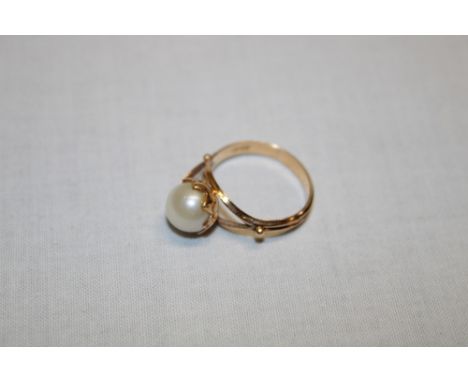 An 18ct gold dress ring with leaf mount set a single pearl