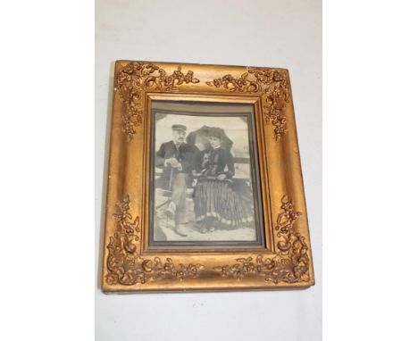 A Victorian rectangular picture frame decorated in relief with flowers, 11" x 9" overall containing a Victorian portrait phot