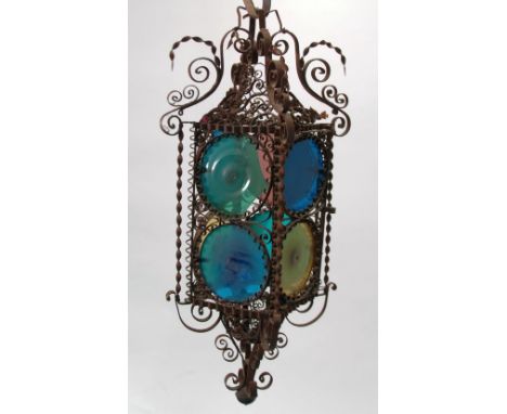 EARLY TWENTIETH CENTURY WROUGHT  METAL AND COLOURED GLASS HALL LANTERN, each of the four circular glazed panel contained in a