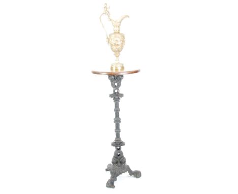 CAST IRON TALL TRIPOD STAND with circular stained wood top, the base incorporating three classical dolphins, 44" (112cm) high