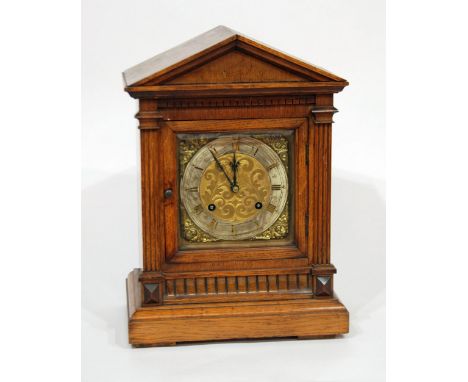 LATE VICTORIAN OAK CASED MANTEL CLOCK, the 7" Roman dial with silvered chapter ring, scroll engraved matted centre and cherub