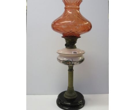 EDWARDIAN OIL LAMP, brass column base oil lamp with decorative milk glass reservoir and cranberry tinted shade