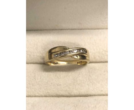 A diamond channel set cross-over ring. The ring stamped 9ct, and signed Browns. Ring size N. Weight 4.1 grams.