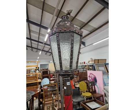 A glazed copper standard lantern raised on a red column and foot