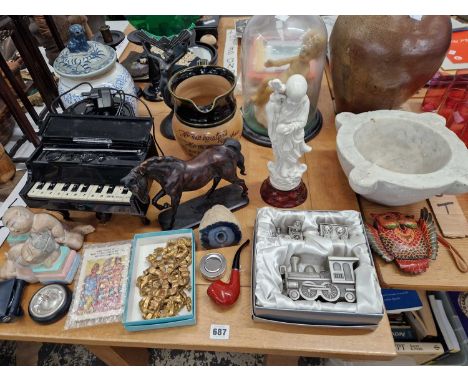 A wax doll figure under a glass dome, a large stone pestle, a piano form CD radio, a art deco style lamp, a Royal Doulton jug