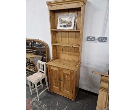 A pine dresser, the enclosed shelf back recessed above a cupboard. H 213 W 74 D 41cms