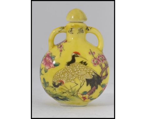 A Chinese enamel painted perfume bottle  - moon flask having yellow ground and decorated with storks - birds. Complete with s