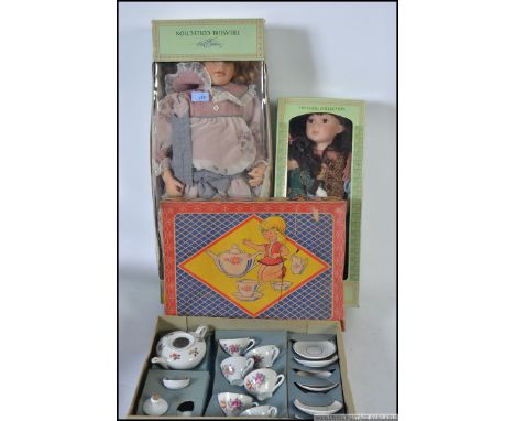 A boxed mid century childs tea service along with two boxed ceramic headed dolls